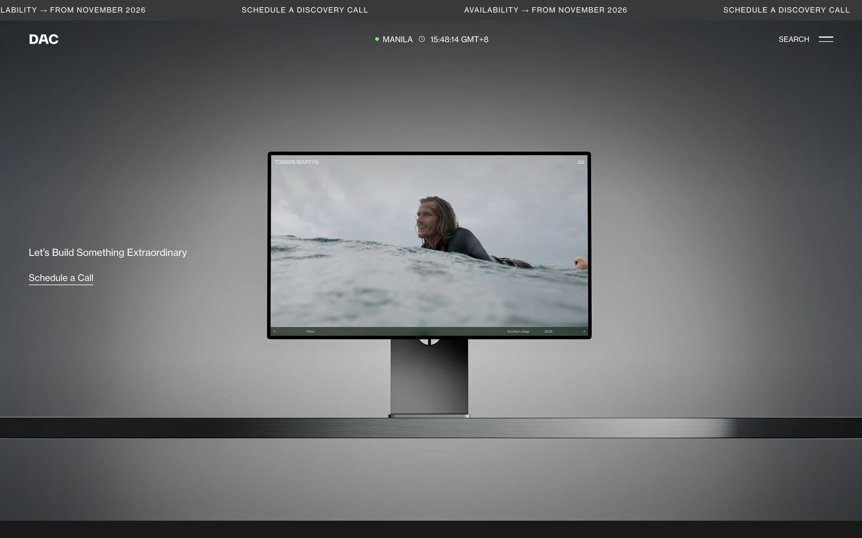DAC Design agency website on desktop with a studio monitor showing a surfing video